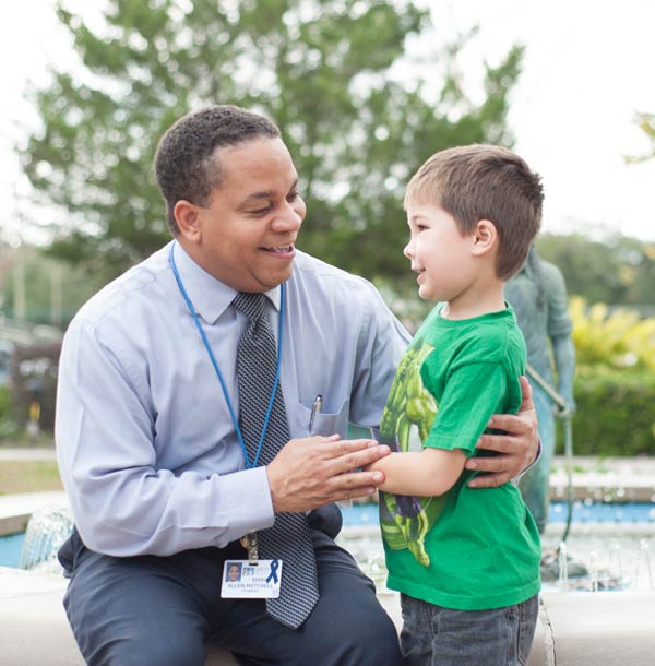 BCM Chaplain Allen Mitchell, who serves Children’s Hospital, shares hugs with patient Braydin LeBlanc. age 7. Photo Credit: Matt Exnicios